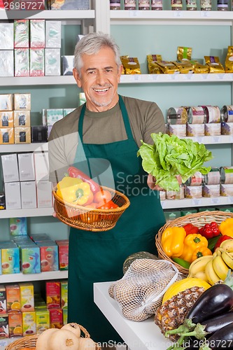 Image of Senior Salesman Selling Vegetables In Supermarket