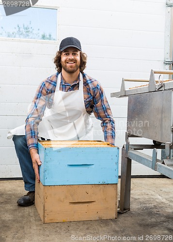 Image of Male Beekeeper With Honeycomb Boxes In Factory