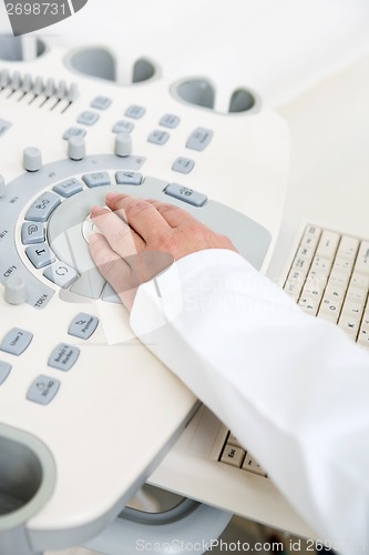Image of Gynecologist's Hand Using Ultrasound Machine