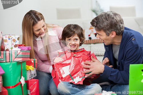 Image of Boy And Parents Opening Christmas Present