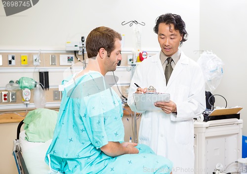 Image of Doctor Discussing Medical Report With Patient In Hospital