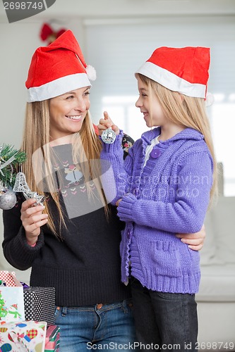 Image of Mother And Daughter Decorating Christmas Tree