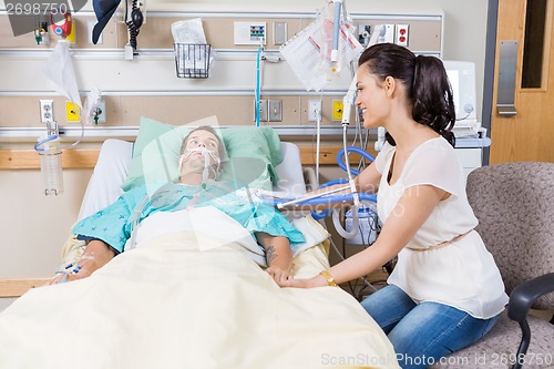 Image of Woman Looking At Man Lying On Bed