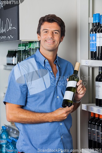 Image of Man Displaying Wine Bottle In Supermarket