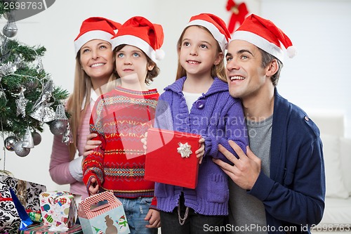 Image of Family In Santa Hats With Christmas Gift