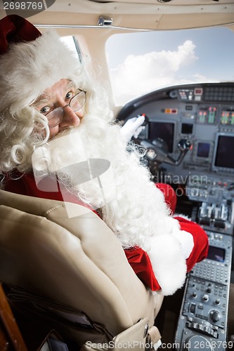 Image of Man In Santa Costume Sitting In Private Jet's Cockpit