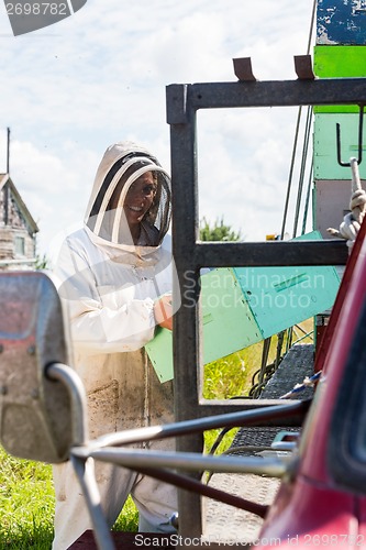 Image of Beekeeper Carrying Honeycomb Crate By Truck