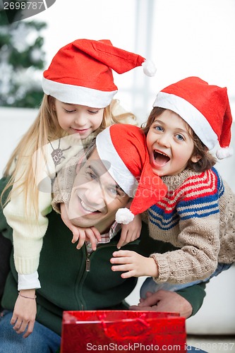 Image of Father Piggybacking Children During Christmas