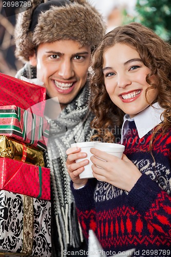 Image of Couple With Disposable Cups And Christmas Presents