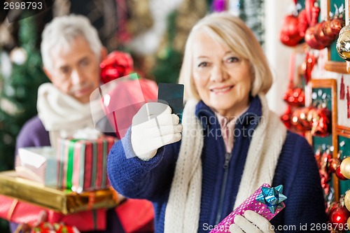 Image of Woman Holding Credit Card At Christmas Store