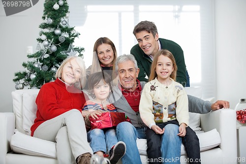 Image of Family With Christmas Present In House