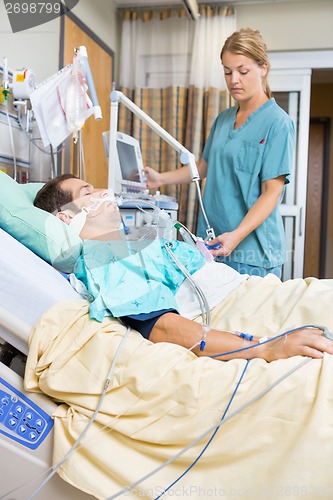 Image of Nurse Examining Patient Lying On Bed