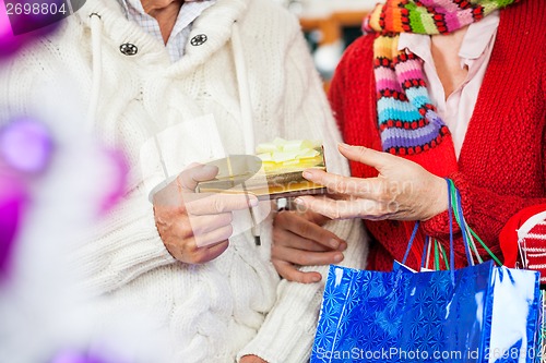 Image of Couple Holding Christmas Present At Store