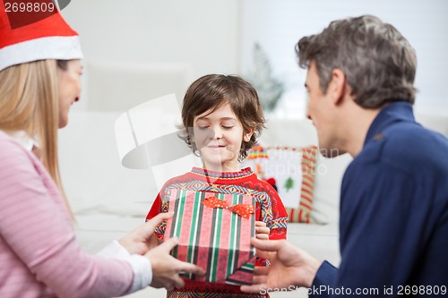 Image of Parents Giving Christmas Present To Son