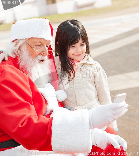 Image of Girl And Santa Claus Taking Selfportrait Through Smartphone