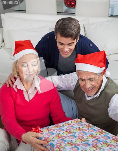 Image of Family Looking At Christmas Present