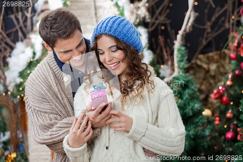 Image of Couple With Christmas Present At Store