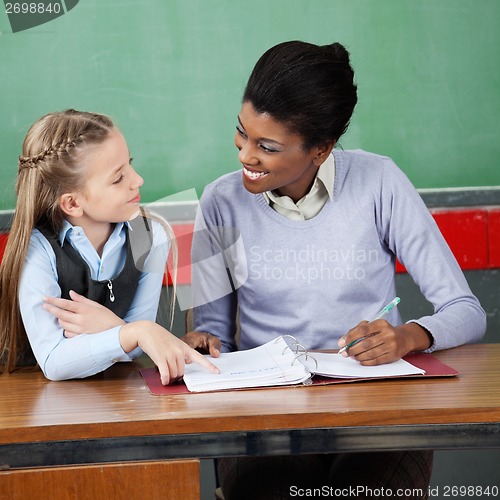 Image of Professor Looking At Schoolgirl At Desk