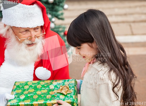 Image of Girl Taking Christmas Gift From Santa Claus