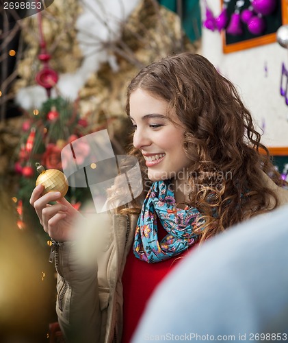 Image of Woman Looking At Golden Bauble In Store