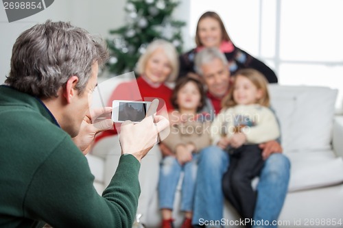 Image of Father Photographing Family Through Smartphone