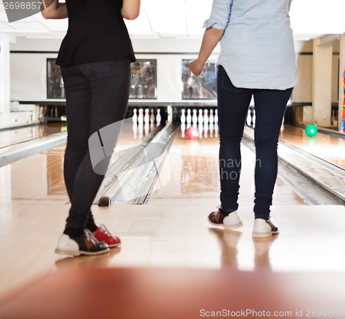 Image of Female Friends Bowling in Club