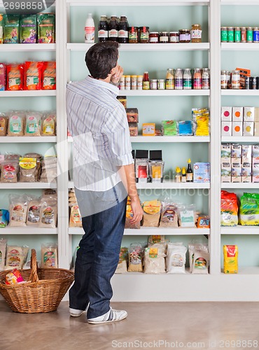 Image of Thoughtful Man Choosing Products In Supermarket