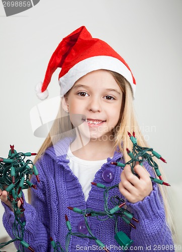 Image of Girl In Santa Hat Holding Fairy Lights