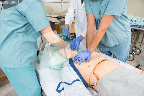 Image of Nurses And Doctor Performing CPR On Dummy