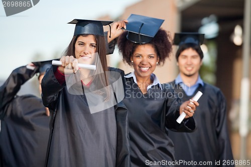 Image of Female Students Showing Certificates On College Campus