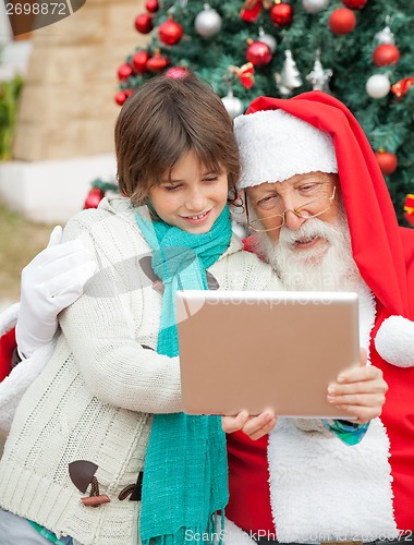 Image of Santa Claus Using Digital Tablet With Boy