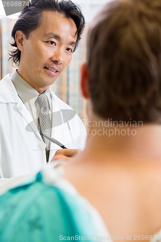 Image of Doctor Looking At Patient While Discussing Report