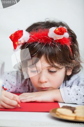 Image of Boy Wearing Santa Headband Writing Letter To Santa Claus