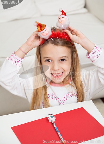 Image of Happy Girl Holding Santa Headband