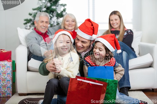 Image of Children And Father With Gifts During Christmas