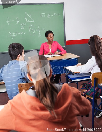 Image of Teacher And Teenage Students Sitting In Classroom