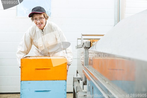 Image of Portrait Of Beekeeper With Honeycomb Crates At Factory