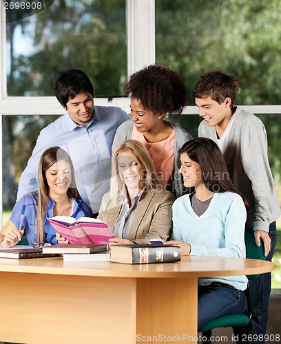Image of College Teacher Explaining Lesson To Students In Classroom