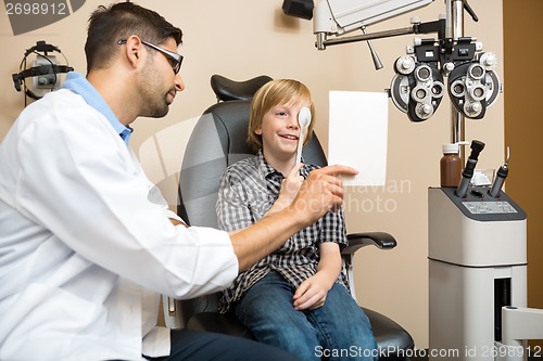 Image of Boy Covering Eye with Occluder at Optometrist