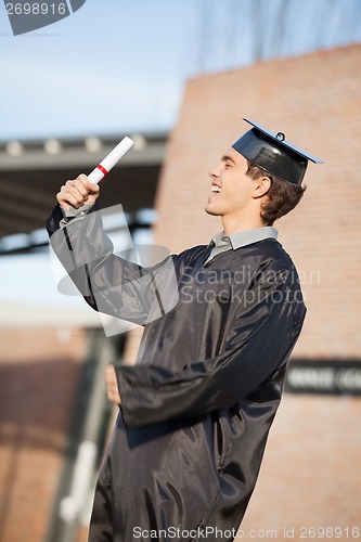 Image of Man Holding Diploma On Graduation Day At Campus