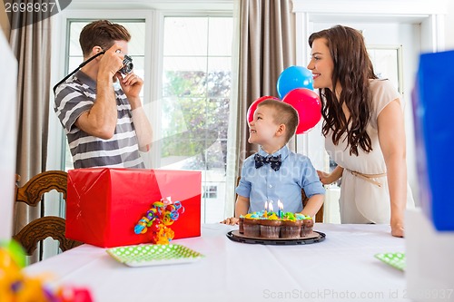 Image of Father Taking Picture Of Birthday Boy And Woman