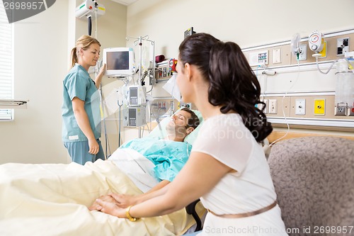 Image of Woman Holding Patient's Hand In Hospital