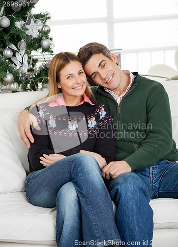 Image of Couple Sitting On At Home During Christmas
