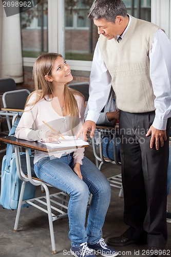 Image of Male Professor Explaining Test To Student In Classroom