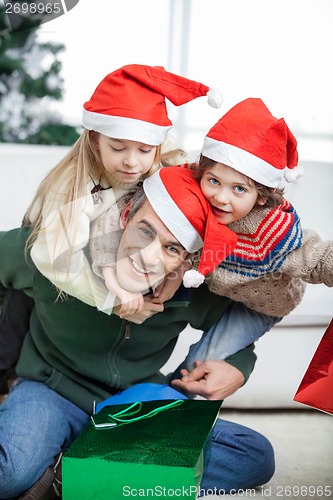 Image of Father Piggybacking Children During Christmas