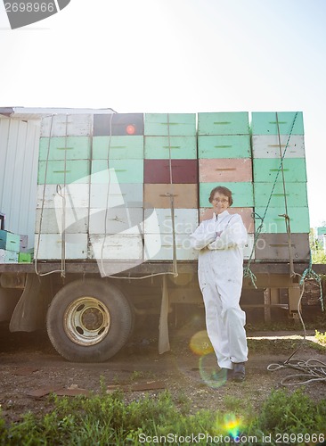 Image of Beekeeper Standing Against Truck Loaded With Honeycomb Crates