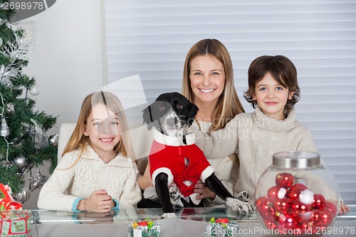 Image of Happy Family With Pet Dog During Christmas