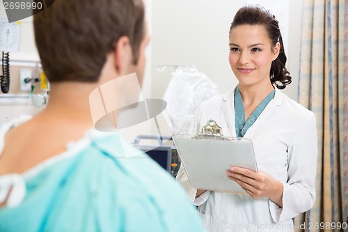 Image of Doctor With Clipboard Smiling At Patient