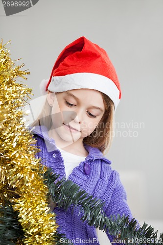 Image of Girl Looking At Tinsels During Christmas