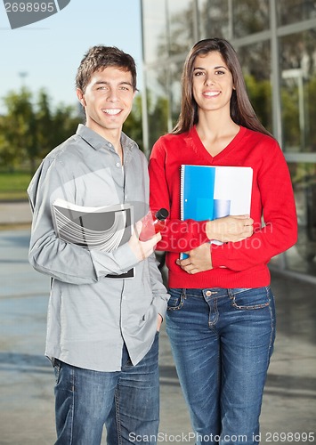 Image of Students Holding Books While Standing In College